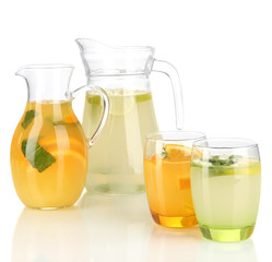 Orange and lemon lemonade in pitchers and glasses isolated