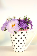 Beautiful bouquet of bright flowers in color mug,