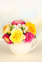 Beautiful bouquet of bright flowers in color mug,