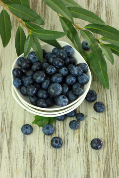Blueberries in bowls on wooden table