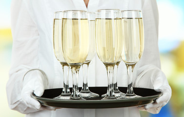 Waitresses holding tray with glasses of champagne