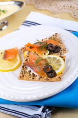 Salmon sandwiches on plate  on wooden table close-up