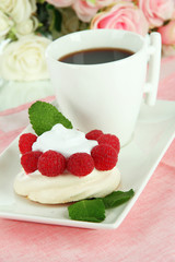 Tasty meringue cake with berries and cup of coffee