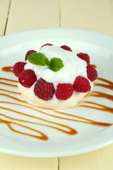 Tasty meringue cake with berries on wooden table