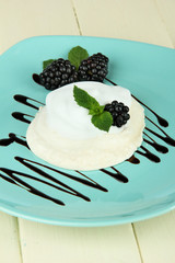 Tasty meringue cake with berries on wooden table
