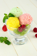 Tasty ice cream scoops, on wooden table