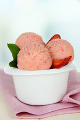 Tasty ice cream scoops in bowl, on table