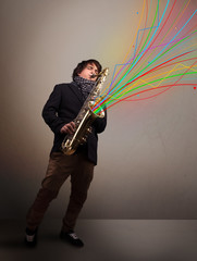 Attractive musician playing on saxophone while colorful abstract