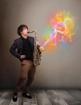 Attractive musician playing on saxophone with colorful abstract