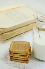 Short pastry and milk bottle on vintage doily