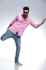 Naklejka premium young fashion man balancing with one leg in his hand