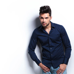 Fototapeta premium young man looks at you with thumbs in pockets
