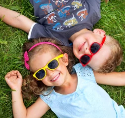 Foto auf Acrylglas Bild zeigt Kinder, die sich auf dem Rasen entspannen © konradbak