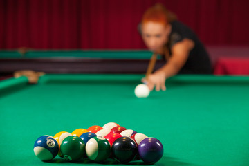 Playing pool. Confident young man aiming the billiard ball with