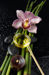 Spa setting with orchid and bamboo grove ,massage oil ,candle