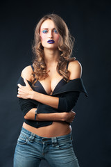 Naklejka premium Young sexy fitness woman on dark wall background.