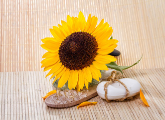 Spa background with natural soap, bath salts, and sunflower.