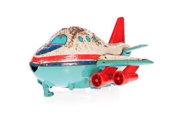 Old Jet plane rusty tin toy isolated on white