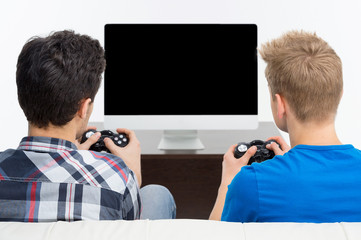 Gamers with joystick. Rear view of two young gamers playing vide