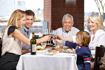 Familie im Restaurant prostet sich zu