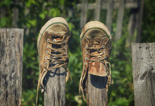 Old Sneakers Hanging On A Fence