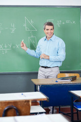 Male Teacher Teaching Mathematics On Board