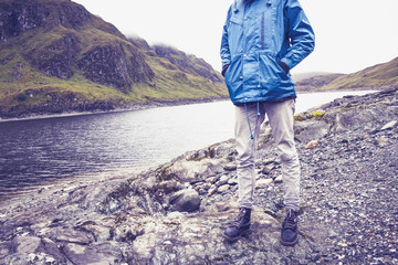 Hillwalker standing by mountain lake