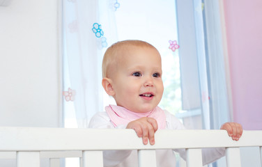 Portrait of a cute baby smiling in crib