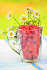 Ripe raspberries in a glass cup