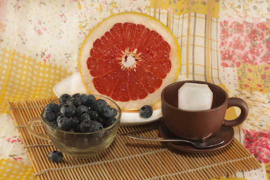 Still life with dietary breakfast: grapefruit, blueberries, tea