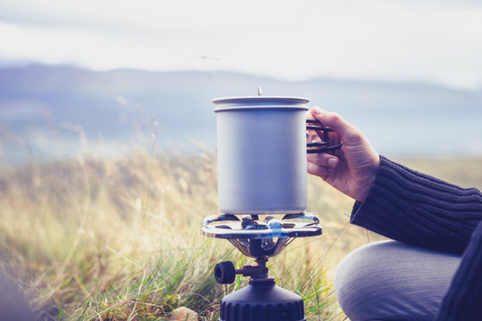 Woman boiling water on portable camping stove