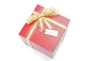 Red gift with a golden bow and tag isolated on white background.