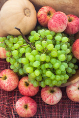 Obraz na płótnie Canvas Autumnal ripe fruits and veg - green grape, red apples and pumpk