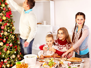 Children rolling dough in kitchen.
