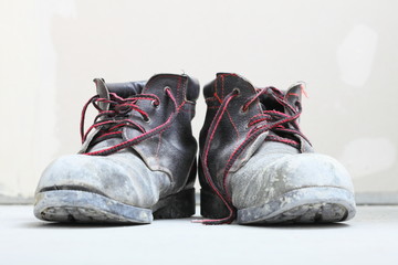  pair of old dirty work boots in building site