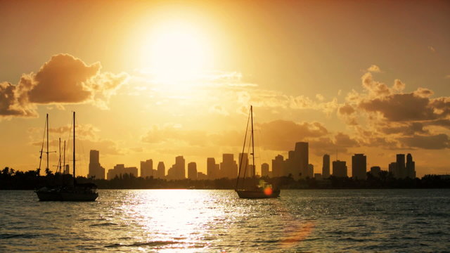 Yachts silhouetted against  Miami Skyline at sunset, USA