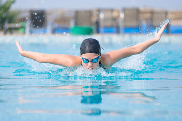 Young girl swimming butterfly stroke style