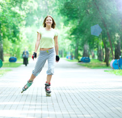 Roller skating sporty girl in park rollerblading on inline skate