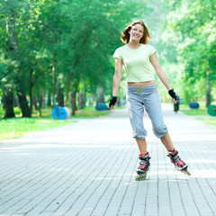 Fototapeta premium Roller skating sporty girl in park rollerblading on inline skate