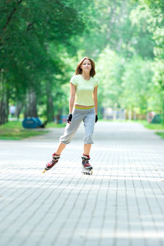 Roller skating sporty girl in park rollerblading on inline skate