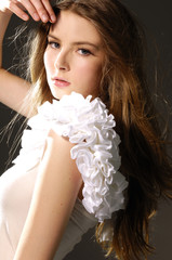 Portrait of pretty young woman in white clothing on black
