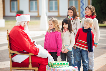 Santa Claus Looking At Children Standing In A Queue