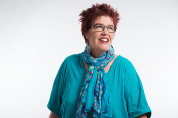 Happy smiling middle aged woman with red short hair and glasses.