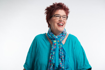 Happy smiling middle aged woman with red short hair and glasses.