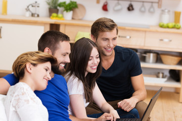 vier freunde schauen zu hause auf laptop