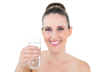 Smiling brunette holding glass of water and looking at camera