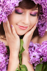 Obraz na płótnie Canvas Young woman with lilac flowers