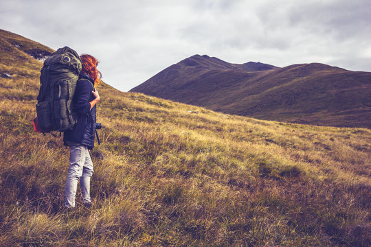 Woman With Backpack About To Climb Mountain