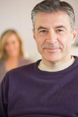 Obraz premium Smiling man with his wife in the background