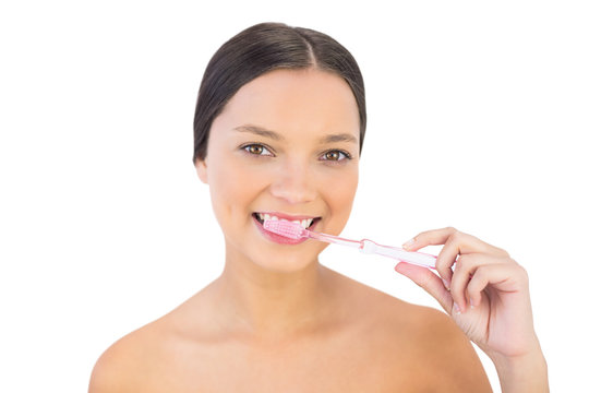 Gorgeous woman brushing her teeth